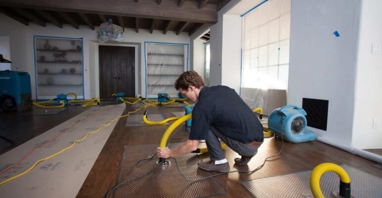 Technician extracting water from a carpeted floor